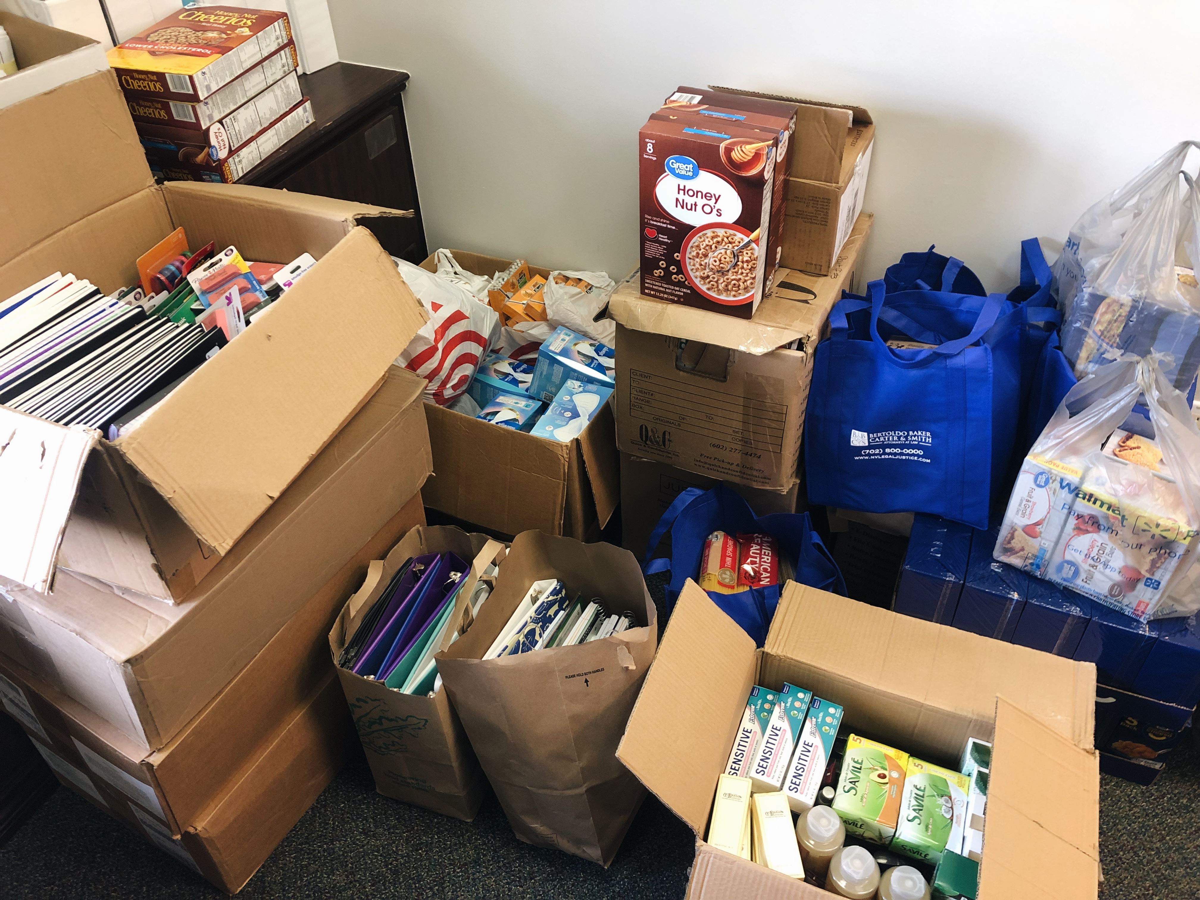 Picture of the boxes of school supplies, including paper, snacks, and feminine supplies