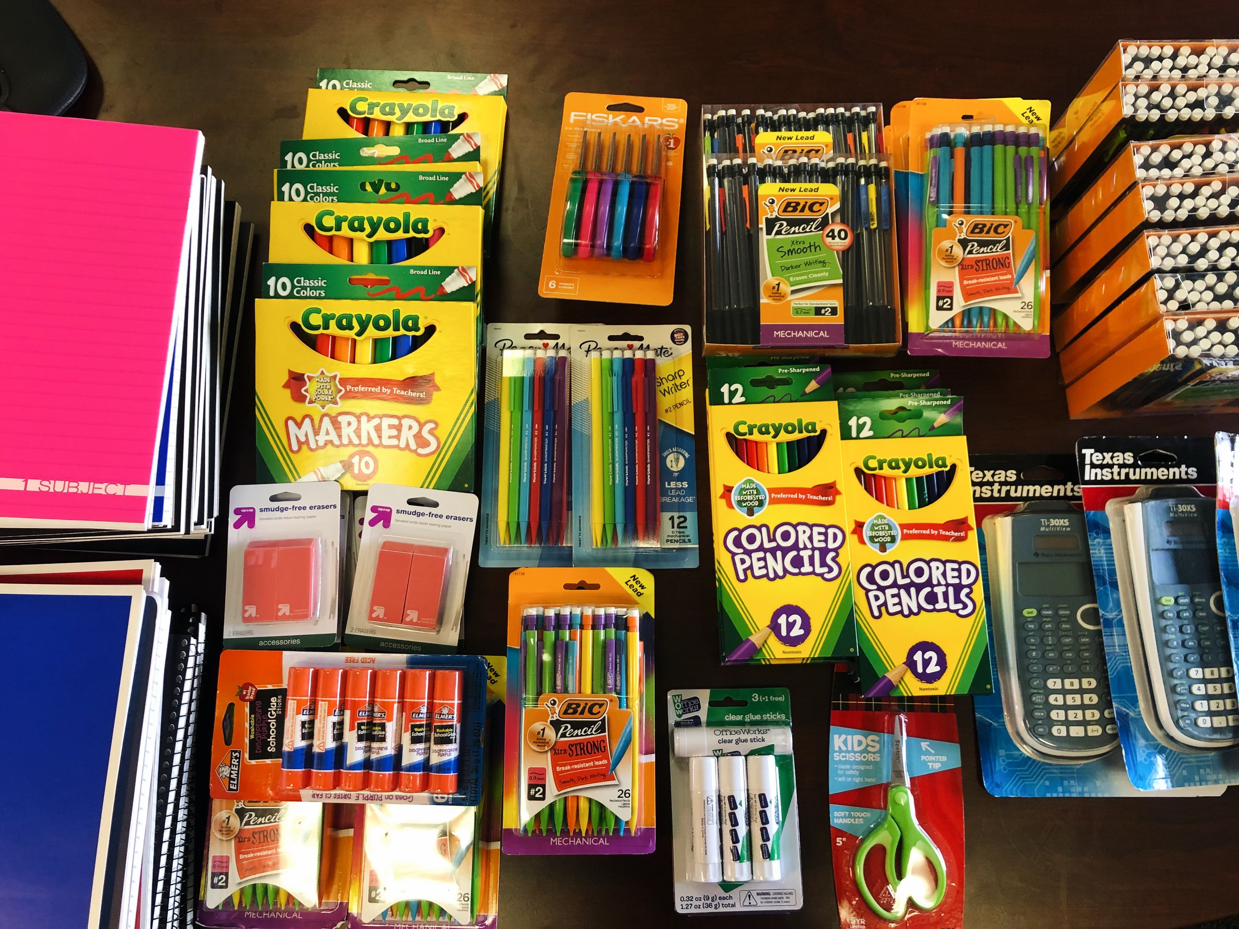 Photo of more school supplies, including boxes of crayons, markers, pens, pencils, etc.