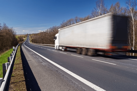 semi truck driving quickly on highway
